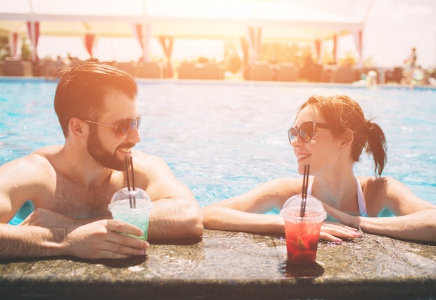 Jeune couple au bord de la piscine