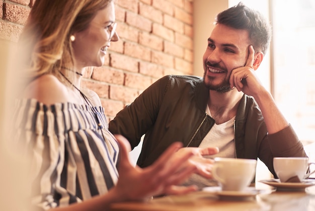 Jeune couple ayant une conversation pendant la pause-café