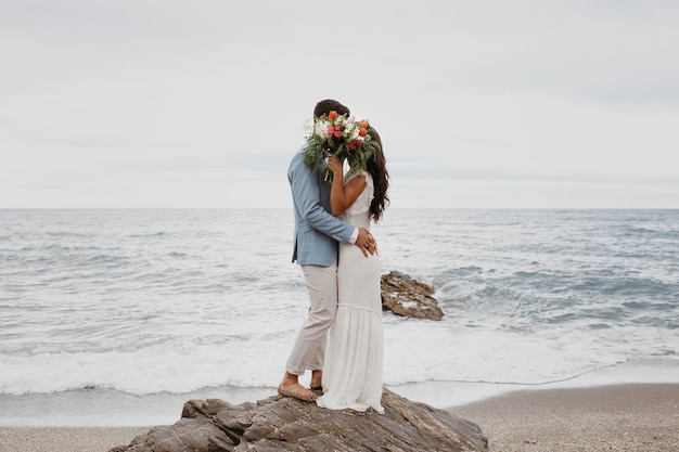 Photo jeune couple ayant un mariage sur la plage