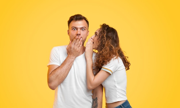 Jeune couple bavardant sur fond jaune