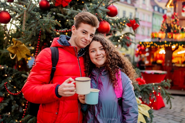 Jeune couple avec des boissons sur le marché de Noël à Wroclaw, Pologne