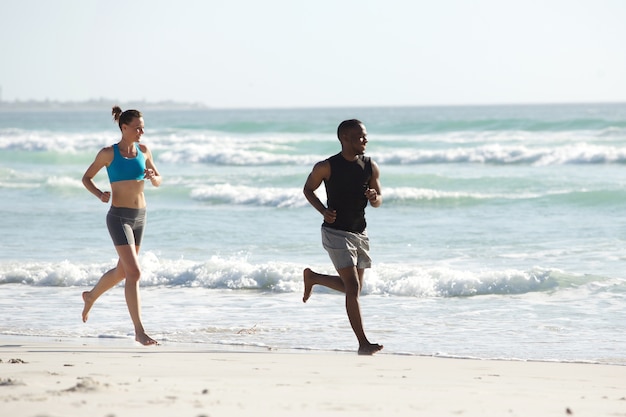 Jeune couple en bonne santé en cours d&#39;exécution sur la plage