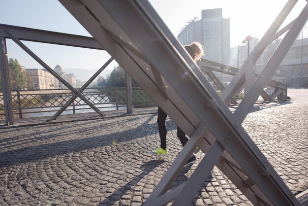 jeune couple en bonne santé faisant du jogging dans la ville tôt le matin avec le lever du soleil en arrière-plan