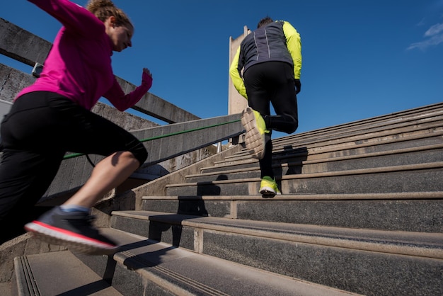 jeune couple en bonne santé faisant du jogging sur les marches tôt le matin