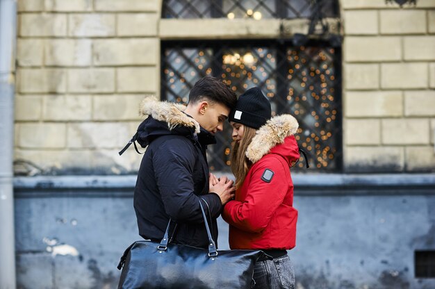 Un jeune couple branché se promène dans la ville à l'heure de Noël.