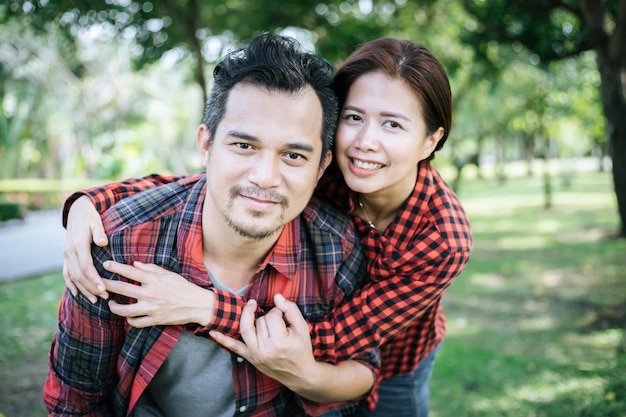 Photo jeune couple avec le bras autour au parc