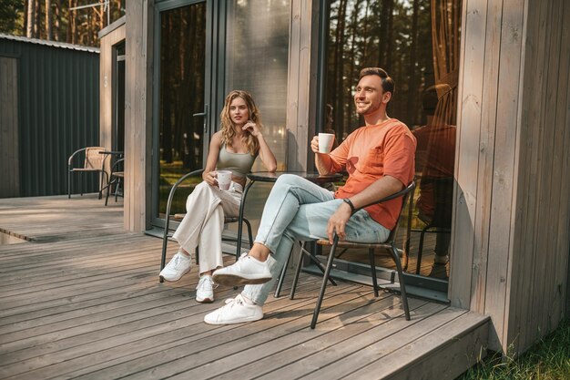 Jeune couple buvant un café sur la terrasse