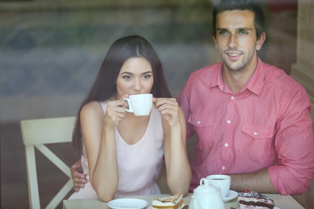 Jeune couple buvant du thé et parlant au café