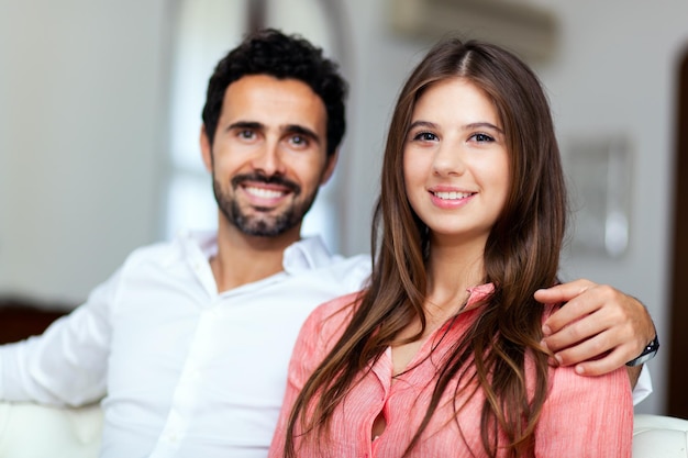 Jeune couple sur le canapé en amour