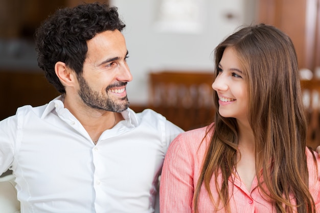 Jeune couple sur le canapé en amour