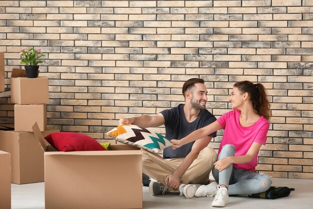 Jeune couple avec des cartons de déménagement à la nouvelle maison