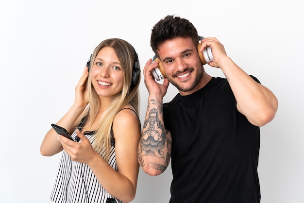 Jeune couple caucasien sur fond blanc, écouter de la musique