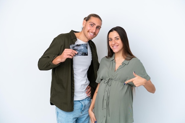 Jeune couple caucasien isolé sur fond blanc enceinte et tenant une échographie