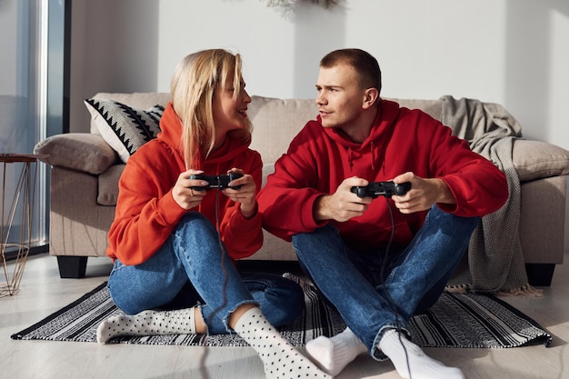 Jeune couple charmant ensemble à la maison jouant à des jeux vidéo le week-end et les vacances ensemble