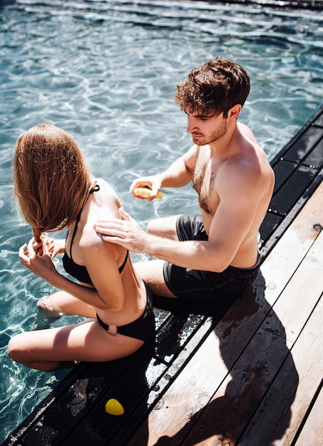 Jeune couple chaud au repos à la piscine