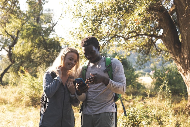 Le jeune couple cherche un chemin dans la forêt