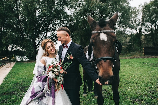 jeune couple avec un cheval noir dans le parc