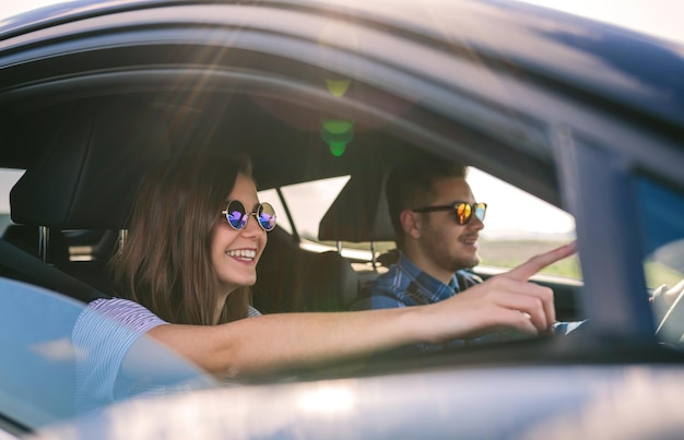 Photo un jeune couple conduit une voiture.