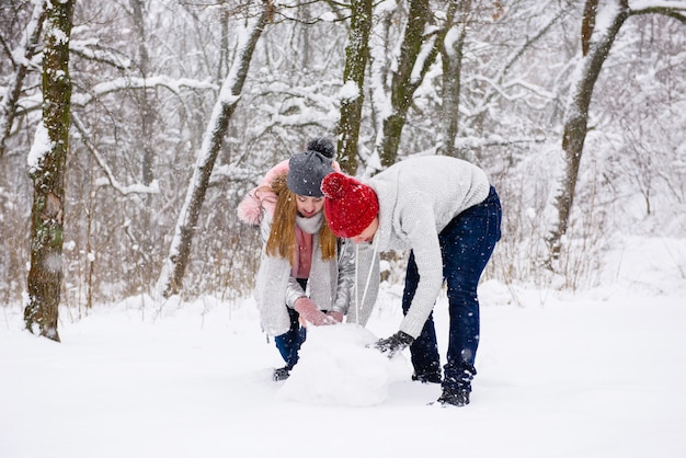 Jeune couple, confection, bonhomme de neige, dans, forêt