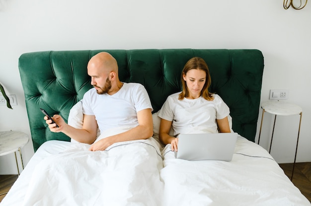 Jeune couple, coucher dans lit, à, téléphones