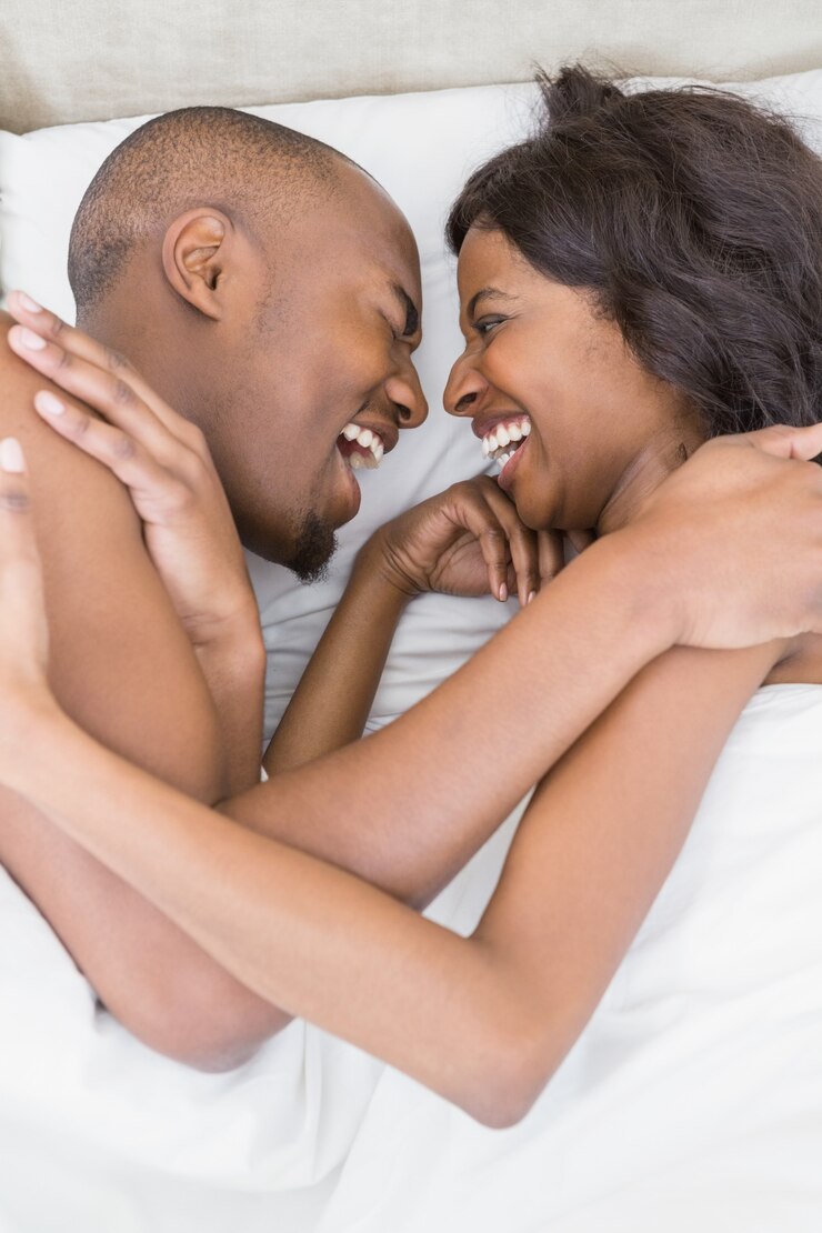 Jeune couple, coucher lit, face à face, et, rire