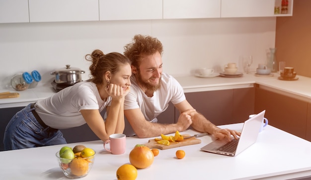 Jeune couple cuisine des aliments sains dans la cuisine à la maison.