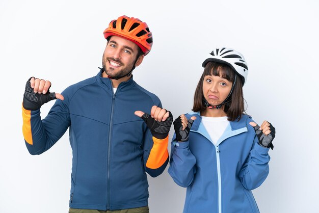 Jeune couple cycliste isolé sur fond blanc fier et satisfait de vous-même concept d'amour