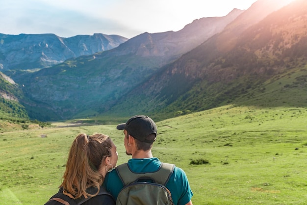 Jeune couple dans une belle vallée entre les montagnes au coucher du soleil Discovery Travel concept
