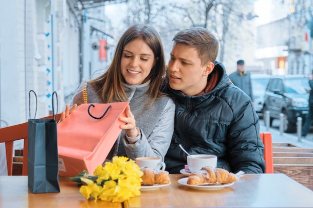 Jeune couple, dans, café extérieur, à, sacs provisions