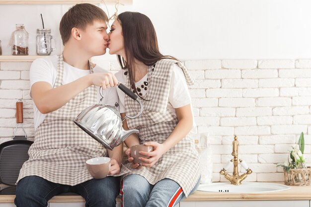 Jeune couple dans la cuisine. Homme et femme cuisinant. Copain et copine à l'intérieur sur la cuisine.