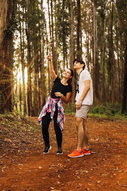 Jeune couple dans la jungle. Les touristes visitent la jungle. Ils regardent les arbres et le soleil brille. Concept de tourisme et de voyage.