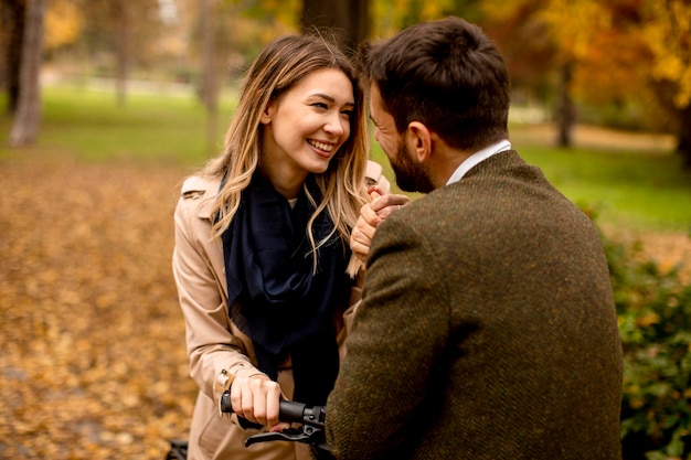 Jeune couple dans le parc en automne avec vélo électrique