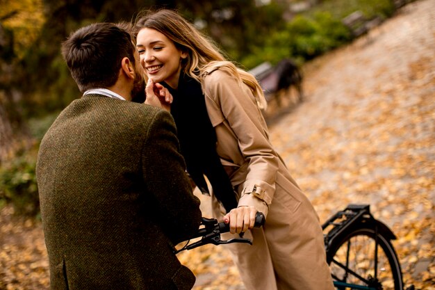 Jeune couple dans le parc en automne avec vélo électrique