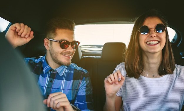 Jeune couple dansant dans la voiture