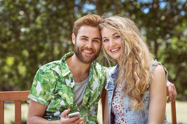 Jeune couple de détente sur le banc de parc