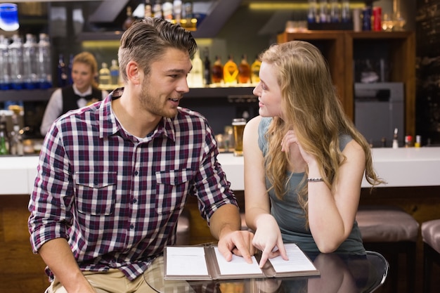 Jeune couple discutant du menu