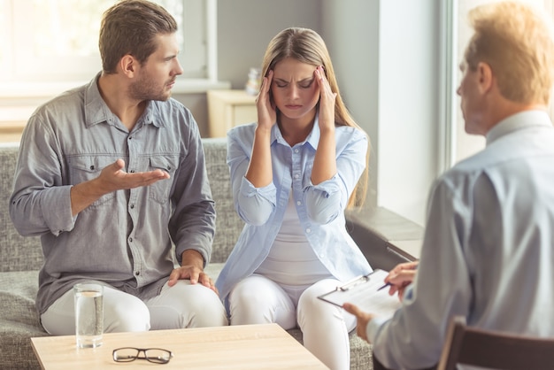 Jeune couple discute assis sur le canapé