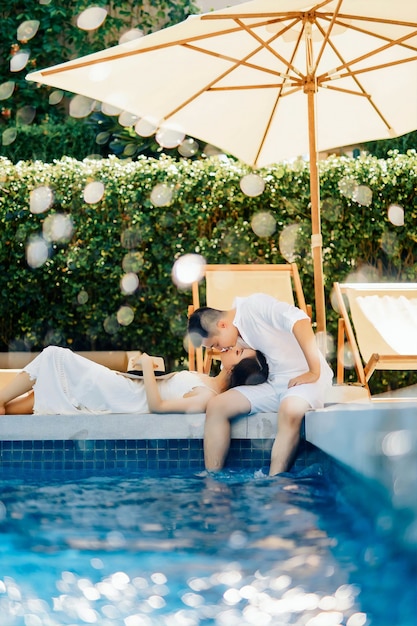 jeune couple donne un baiser sur une piscine