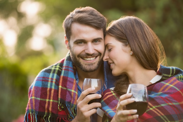 Jeune couple avec du vin enveloppé dans une couverture