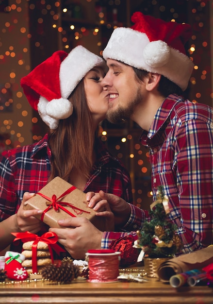 Jeune couple échangeant des cadeaux de Noël