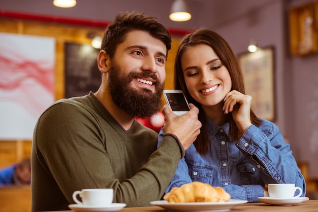 Jeune couple écoute ensemble dans un café.