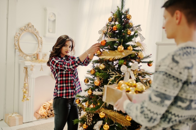 Jeune couple élégant avec des cadeaux de Noël et décoration du nouvel an