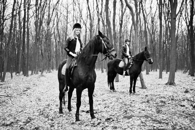 Jeune couple élégant à cheval sur la forêt d'automne