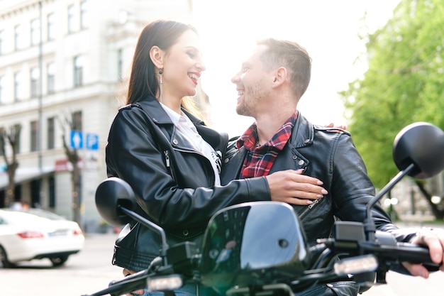 Jeune couple élégant avec une moto dans une rue de la ville