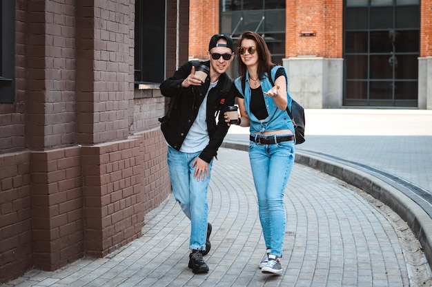 Jeune couple élégant se promène dans la ville avec des lunettes de soleil
