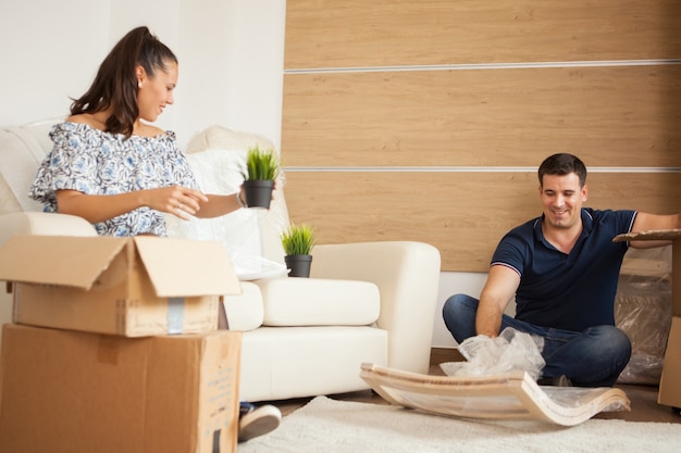 Jeune couple emménageant dans une nouvelle maison et déballant des boîtes en carton. Emménagement presque terminé.