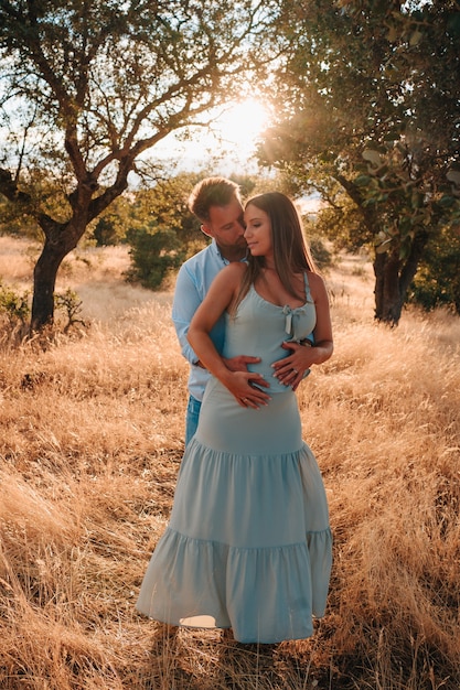 Jeune couple enceinte dans la nature attendant l'arrivée de leur bébé.