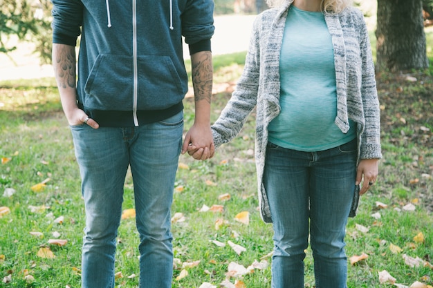 Jeune couple enceinte dans le parc