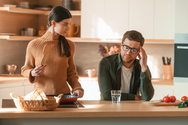 Un jeune couple est ensemble dans la cuisine.
