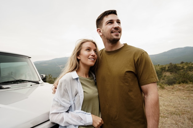 Le jeune couple est en voyage romantique à la montagne en voiture